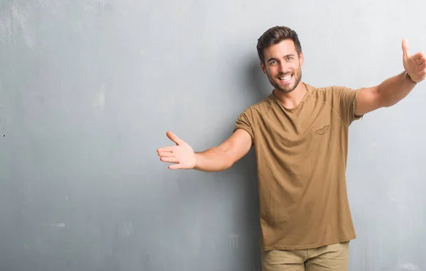 Jovem Bonito Sobre Parede Grunge Cinza Olhando Para Câmera Sorrindo — Fotografia de Stock