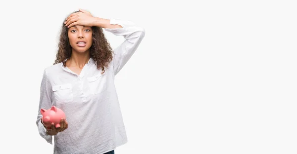 Mulher Hispânica Jovem Segurando Banco Porquinho Estressado Com Mão Cabeça — Fotografia de Stock