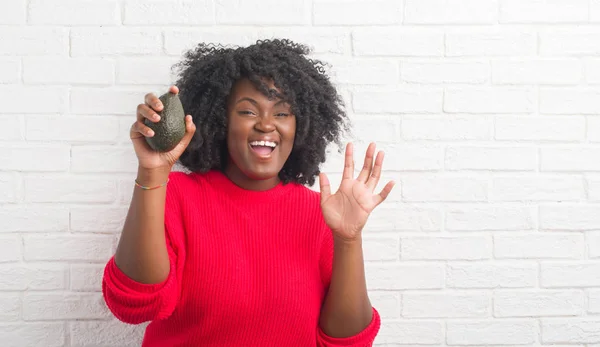 Jovem Afro Americana Sobre Parede Tijolo Branco Comendo Abacate Muito — Fotografia de Stock