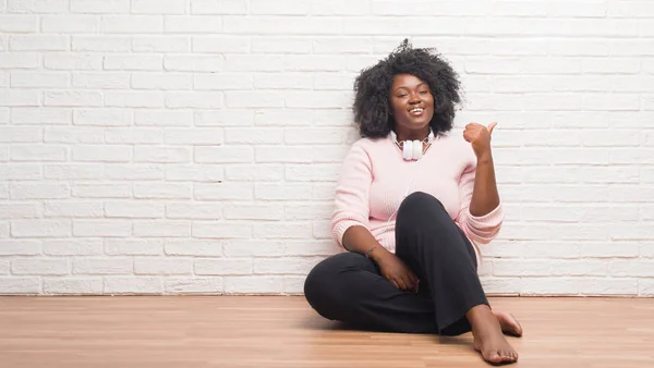 Jonge African American Vrouw Zittend Vloer Dragen Hoofdtelefoon Glimlachend Met — Stockfoto