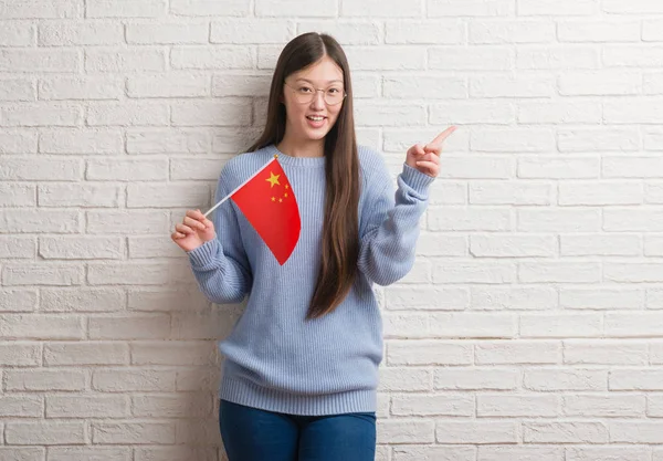 Νέα Κινεζική Γυναίκα Πάνω Από Τον Τοίχο Κρατώντας Την Σημαία — Φωτογραφία Αρχείου