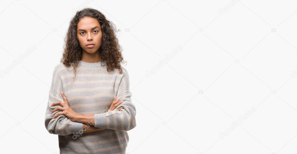 Beautiful young hispanic woman wearing stripes sweater skeptic and nervous, disapproving expression on face with crossed arms. Negative person.