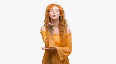 Bir öpücük el ile güzel ve seksi olmak hava üfleme kamera arayan genç Kızıl saçlı kadın. Aşk ifade.