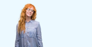 Uzak tarafına yüzünde, doğal ifade gülümseme ile arayan genç redhead bussines kadın. Kendine güvenen gülüyor.