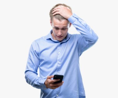 Genç yakışıklı sarışın adam kafasına, el ile vurguladı smartphone kullanarak şok utanç ve sürpriz suratla, öfkeli ve sinirli. Korku ve hata için üzgün.