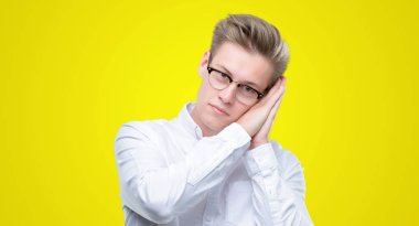 Genç yakışıklı sarışın adam uyku rüya ve elleri ile kapalı gözler gülümseyen birlikte poz yorgun.