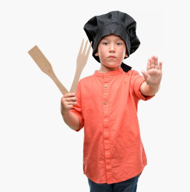 Açık eliyle dur işareti ile ciddi ve kendine güvenen ifade, savunma jest yapıyor Şef üniforma giyen koyu saçlı küçük çocuk