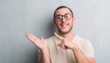 El ve parmak ile işaret çok mutlu gri grunge duvarın üzerinden beyaz delikanlı