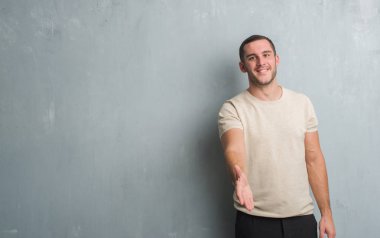 Beyaz delikanlı olarak tebrik ve konuksever dost sunan karşılıklı gülümseyen gri grunge duvarın üzerinden. Başarılı iş.