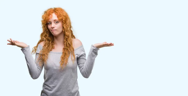 若い赤毛の女性無知と混乱式腕と手を上げて 疑いのコンセプト — ストック写真