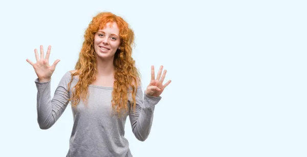 若い赤毛の女性を示すと指で上向きナンバー ナイン自信を持って 幸せな笑みを浮かべて — ストック写真