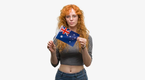 スマートの顔は深刻な思考に自信を持って式にオーストラリアの国旗を保持している赤毛の若い女性 — ストック写真