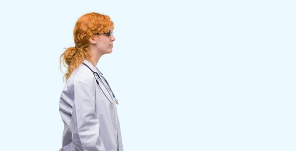 Mujer Pelirroja Joven Vistiendo Uniforme Médico Mirando Lado Pose Perfil —  Fotos de Stock