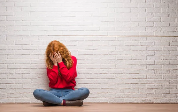 Junge Rothaarige Frau Die Mit Traurigem Gesichtsausdruck Über Backsteinmauern Sitzt — Stockfoto