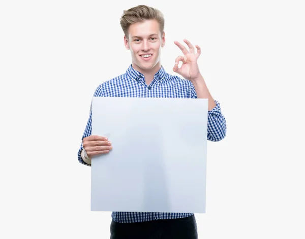 Joven Hombre Rubio Guapo Sosteniendo Una Pancarta Haciendo Signo Con — Foto de Stock