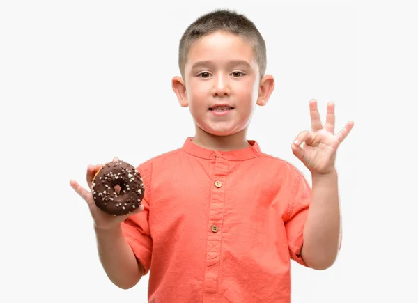 Criança Cabelos Escuros Comendo Donut Fazendo Sinal Com Dedos Excelente — Fotografia de Stock