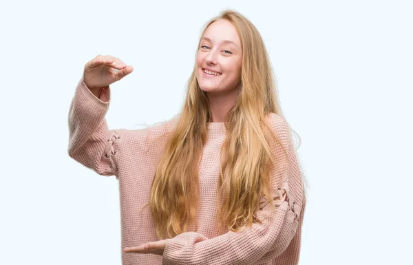 ピンクのセーターが示す大きな手 大型サイン メジャー シンボルでジェスチャーを着て金髪 代女性 カメラを見て笑っています 測定概念 — ストック写真