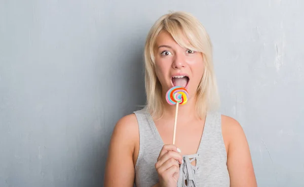 Caucásico Mujer Adulta Sobre Gris Grunge Pared Comer Caramelo Lollipop — Foto de Stock