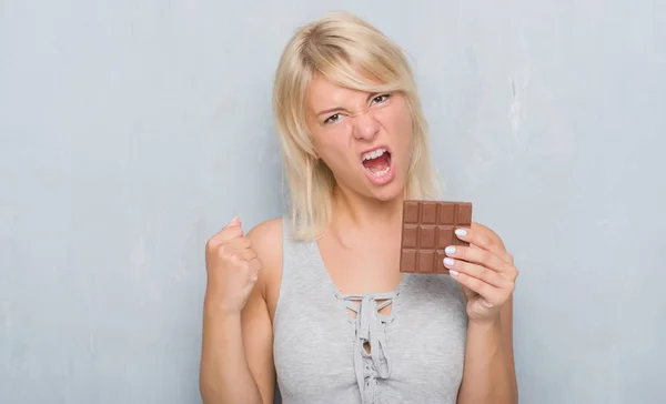 Caucásico Mujer Adulta Sobre Gris Grunge Pared Comer Chocolate Bar —  Fotos de Stock