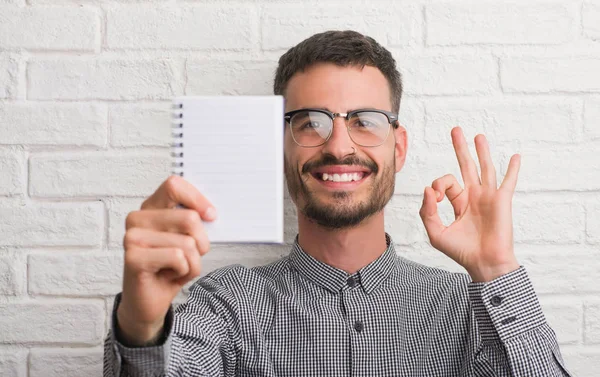 Giovane Uomo Adulto Possesso Notebook Piedi Sopra Muro Mattoni Bianchi — Foto Stock