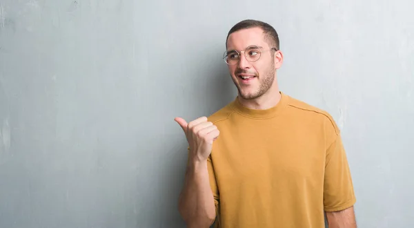 Homem Caucasiano Jovem Sobre Parede Grunge Cinza Apontando Mostrando Com — Fotografia de Stock