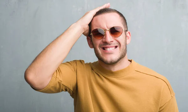 Homem Caucasiano Jovem Sobre Parede Grunge Cinza Usando Óculos Sol — Fotografia de Stock