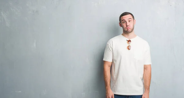 Joven Caucásico Hombre Sobre Gris Grunge Pared Usando Gafas Sol — Foto de Stock