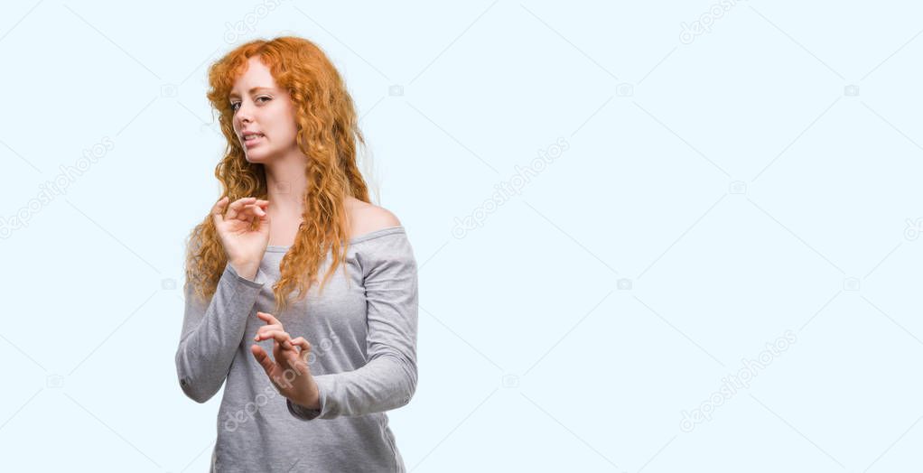 Young redhead woman disgusted expression, displeased and fearful doing disgust face because aversion reaction. With hands raised. Annoying concept.