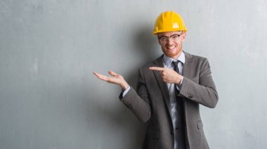 Mimar kıyafeti ve helment çok mutlu el ve parmak ile işaret giyen genç Kızıl saçlı adam