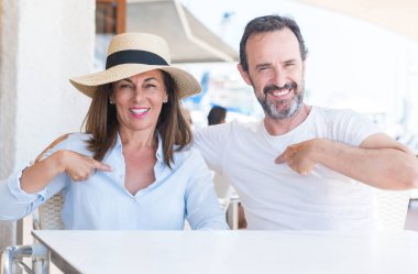 Orta yaş kaç sürpriz ile terasında oturup kendine işaret parmağı yüz