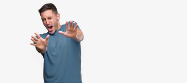 Şokta bağırarak rahat yakışıklı genç korkuyor ve korku ifade dur hareketi el ile ile çok korkmuş. Panik kavramı.