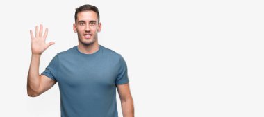 Gösterilen ve parmakları ile işaret yakışıklı genç casual adam kendinden emin ve mutlu gülümseyerek süre beş numara.