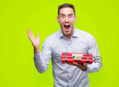 Yakışıklı genç iş adamı ile çığlık zaferini kutluyor bir çalar saat bomba çok mutlu ve heyecanlı, kazanan ifade büyük tutarak gülümseyin ve el kaldırdı