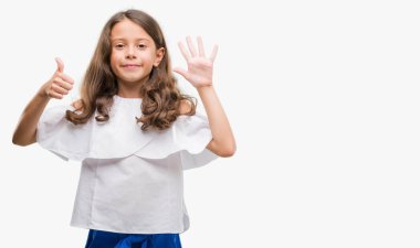 Gösterilen ve parmakları ile işaret esmer Latin kız kendinden emin ve mutlu gülümseyerek süre 6 numara.