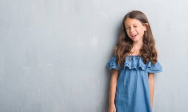 Grunge genç İspanyol çocuk gri duvar kırpışan kameraya seksi bir ifadeyle, neşeli ve mutlu yüz arıyorum.