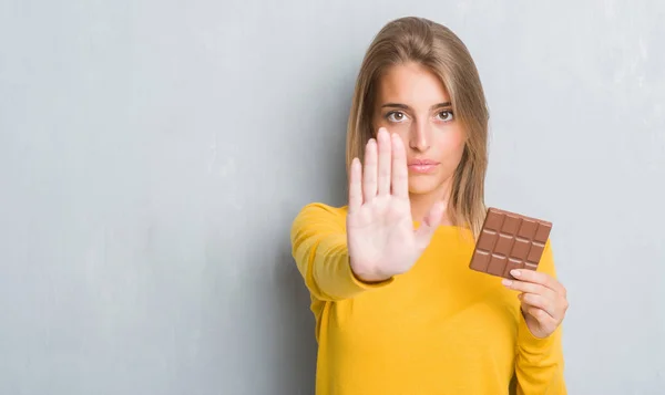 Schöne Junge Frau Über Grunge Grey Wall Eating Chocolate Bar — Stockfoto