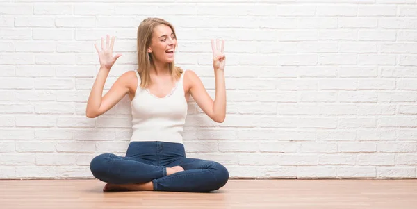 Mooie Jonge Vrouw Zittend Vloer Thuis Tonen Met Vingers Omhoog — Stockfoto