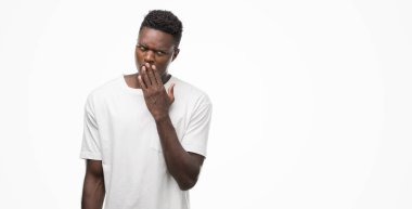 Beyaz t-shirt giyen genç Afro-Amerikan adam el ağzıyla kapsayan yorgun esneme sıkılmış. Restless ve uyku hali.