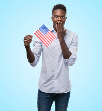 ABD bayrağı kapak ağız hata, korku, sessizlik içinde gizli kavramı korkmuş ifade için utanç ile şok eliyle tutan genç Afro-Amerikan adam