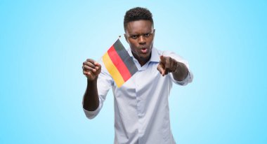 Alman bayrağı kamera ve size, el işareti, pozitif ve kendinden emin bir jest ön parmak ile işaret tutan genç Afro-Amerikan adam