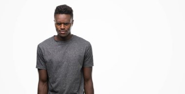 Gri t-shirt şüpheci ve sinir, papatyanın üzgün sorunu nedeniyle giyen genç Afro-Amerikan adam. Negatif kişi.