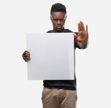 Bir afiş ile tutan genç Afro-Amerikan adam dur işareti ile ciddi ve kendine güvenen ifade, savunma hareketi yaparken el açmak