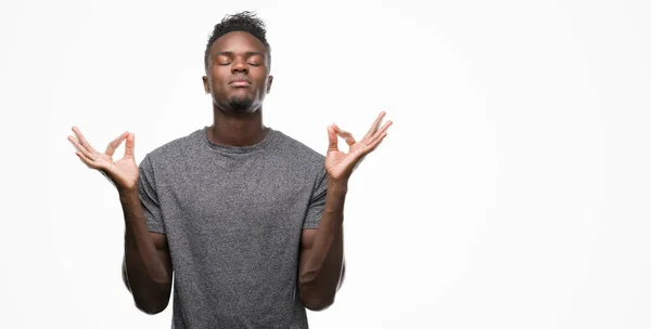 灰色の シャツを着て若いアフリカ系アメリカ人のリラックスし 瞑想の指ジェスチャーをやって閉じた目を浮かべてします ヨガの概念 — ストック写真