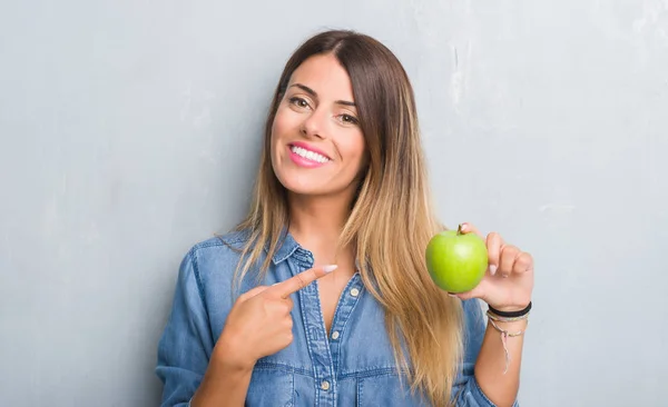 Jovem Mulher Adulta Sobre Parede Grunge Cinza Comendo Maçã Verde — Fotografia de Stock