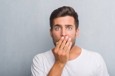 Yakışıklı genç gri grunge duvar kapağı ağız için hata, ifade korku, utanç ile şok el ile üzerinden sessizlik içinde gizli kavramı korkuttu