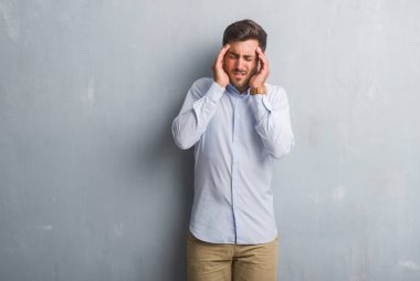 Yakışıklı genç iş adamı gri grunge üzerinde duvar el ile zarif forması giyen baş ağrısı için kafasına çünkü stres. Migren muzdarip.