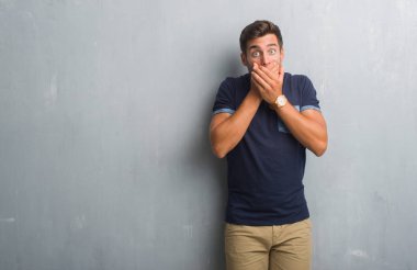 Gri grunge duvar eller için hata ile ağız kapsayan şok yakışıklı genç adam. Gizli kavramı.