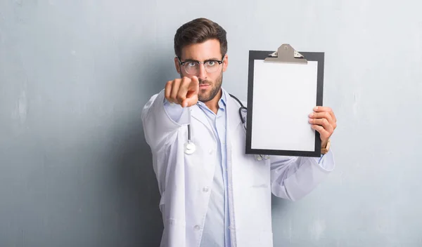 Bonito Jovem Médico Homem Sobre Parede Grunge Cinza Segurando Prancheta — Fotografia de Stock