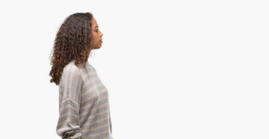 Güzel genç İspanyol kadın giyiyor çizgili süveter tarafa bakarak dinlenmek doğal yüz emin gülümseme ile pozuyla profil.