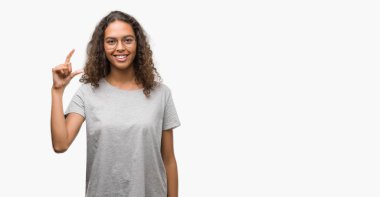 Gülümseyen bardakları ve süre seyir ve kamera boyutu işaret parmaklarıyla yapıyor el ile kendine güvenen el hareketi giyen güzel genç İspanyol kadın. Ölçü kavramı.